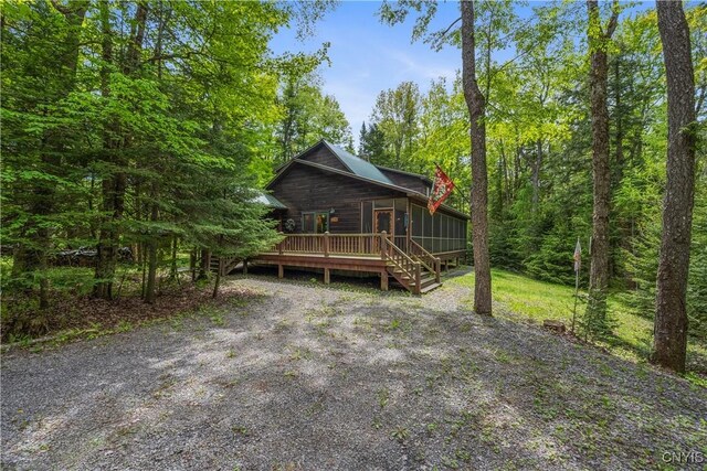 12103 Kincaid Rd, Forestport, NY 13338 - view of front of house featuring a sunroom, a wooden deck, and a view of trees