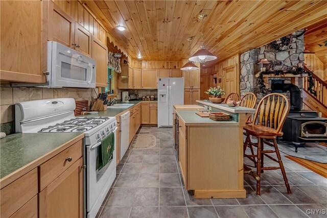 12103 Kincaid Rd, Forestport, NY 13338 - kitchen featuring white appliances, a breakfast bar, a kitchen island, tile patterned flooring, and wooden ceiling