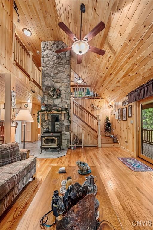 12103 Kincaid Rd, Forestport, NY 13338 - living area featuring wood ceiling, vaulted ceiling, wood-type flooring, a wood stove, and ceiling fan