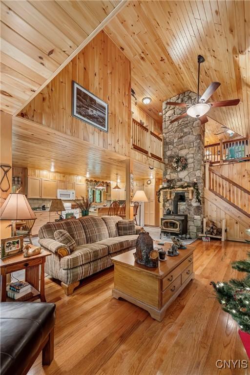 12103 Kincaid Rd, Forestport, NY 13338 - living area featuring wood ceiling, ceiling fan, wooden walls, wood finished floors, and high vaulted ceiling