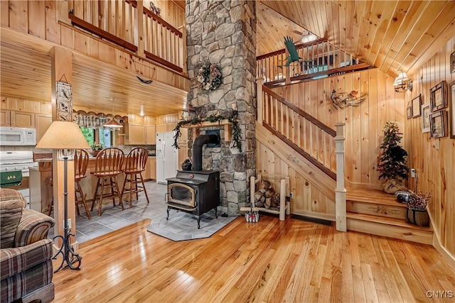 12103 Kincaid Rd, Forestport, NY 13338 - living area with a wood stove, hardwood / wood-style flooring, stairs, wood walls, and lofted ceiling