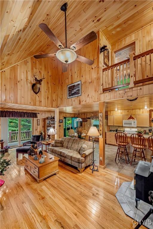 12103 Kincaid Rd, Forestport, NY 13338 - living area with wood walls, high vaulted ceiling, ceiling fan, hardwood / wood-style flooring, and wood ceiling