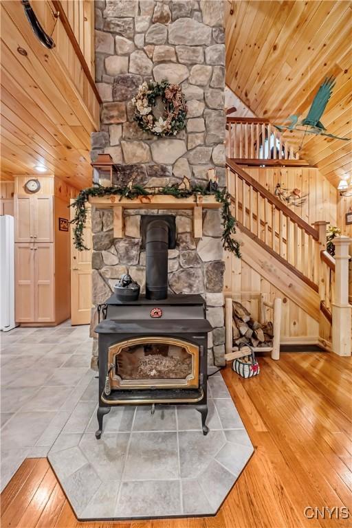 12103 Kincaid Rd, Forestport, NY 13338 - detailed view of wood ceiling, a wood stove, wood finished floors, and freestanding refrigerator