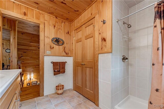 12103 Kincaid Rd, Forestport, NY 13338 - bathroom with tiled shower, vanity, wooden walls, and tile patterned floors