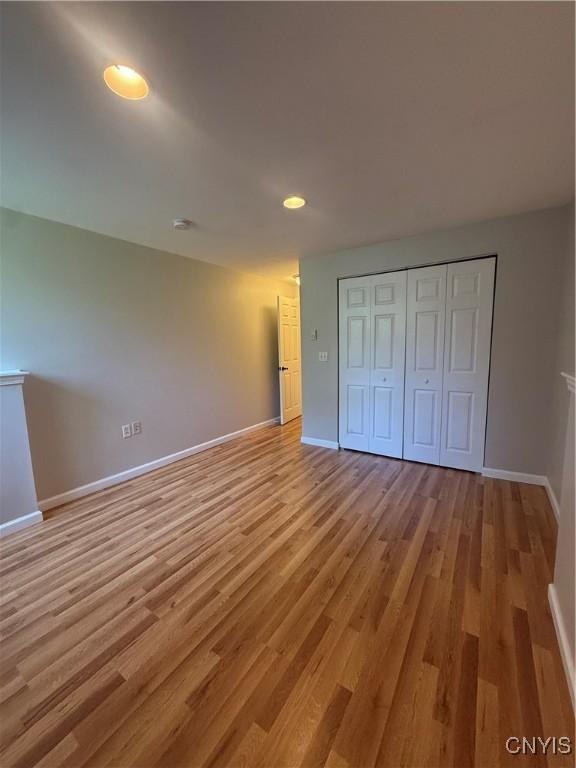 137 Watertree Dr, Dewitt, NY 13057 - unfurnished bedroom with baseboards, light wood-type flooring, recessed lighting, and a closet