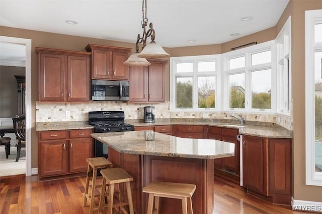 82 Arcadian Dr, Amherst, NY 14228 - kitchen with stainless steel microwave, black range with gas cooktop, a sink, brown cabinets, and recessed lighting