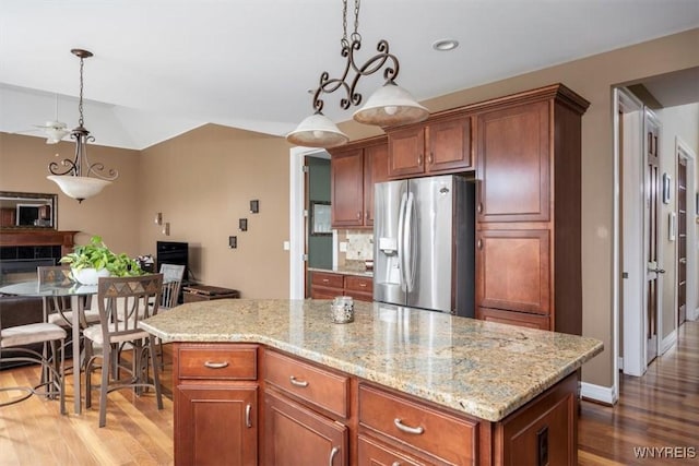 82 Arcadian Dr, Amherst, NY 14228 - kitchen featuring stainless steel fridge with ice dispenser, wood finished floors, decorative light fixtures, and light stone countertops