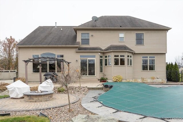 82 Arcadian Dr, Amherst, NY 14228 - rear view of property with a pergola, an outdoor fire pit, a patio, and a covered pool