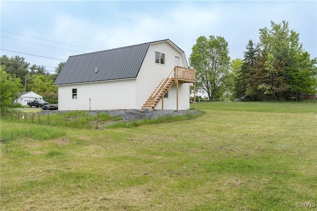 29580/584 Maple St Unit 584, Le Ray, NY 13612 - view of side of property with stairway, a gambrel roof, a yard, a deck, and metal roof
