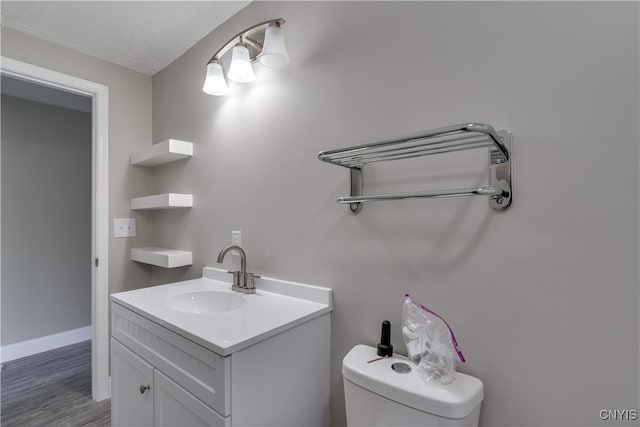 29580/584 Maple St Unit 584, Le Ray, NY 13612 - bathroom featuring vanity, toilet, baseboards, and wood finished floors