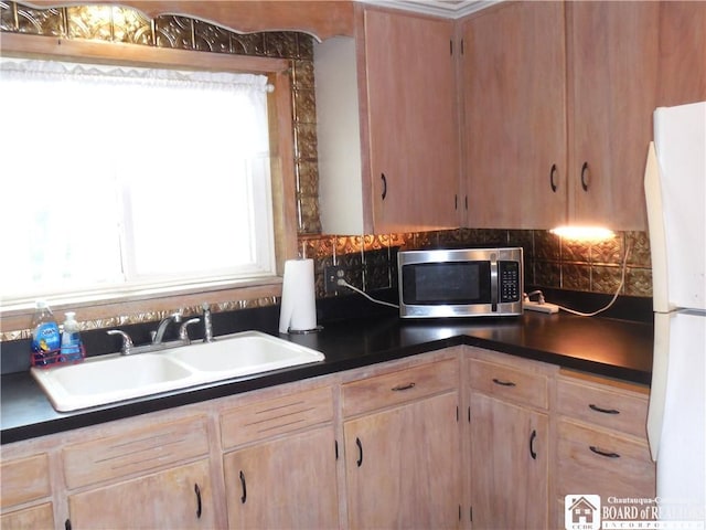 123 N Dow St, Ellicott, NY 14733 - kitchen with stainless steel microwave, freestanding refrigerator, a sink, light brown cabinets, and dark countertops