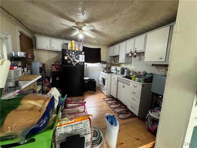 403 Coffeen St, Watertown-City, NY 13601 - kitchen with white gas range oven, freestanding refrigerator, light wood finished floors, ceiling fan, and light countertops