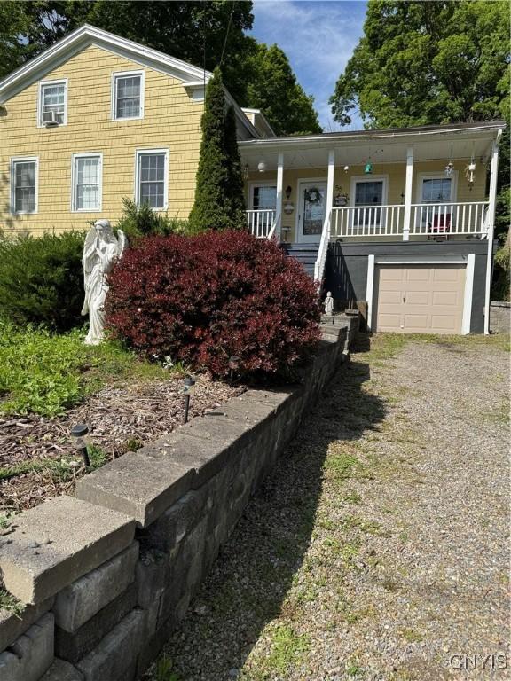 58 S Hamilton St, Elbridge, NY 13080 - view of front facade featuring a porch, gravel driveway, and an attached garage