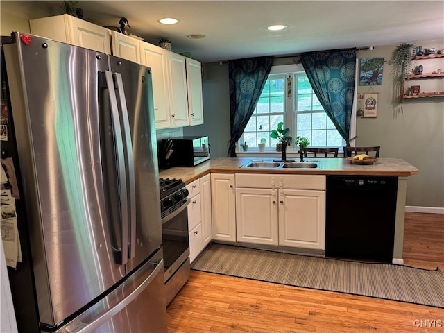 58 S Hamilton St, Elbridge, NY 13080 - kitchen featuring stainless steel appliances, a sink, light wood-style floors, a peninsula, and white cabinetry