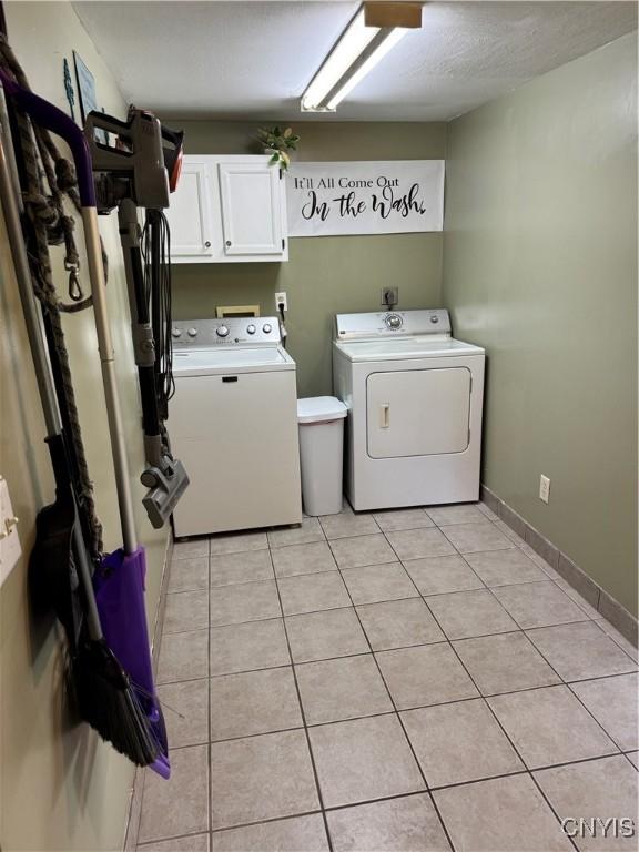 58 S Hamilton St, Elbridge, NY 13080 - washroom featuring cabinet space, independent washer and dryer, and light tile patterned floors