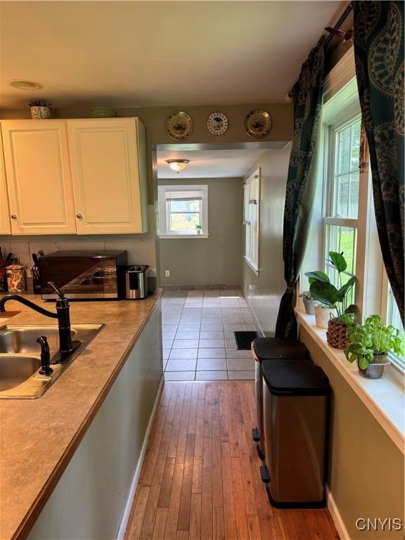58 S Hamilton St, Elbridge, NY 13080 - kitchen featuring a sink, light wood-style floors, white cabinets, and light countertops