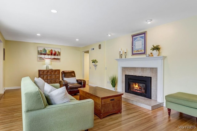 515 Park Club Ln, Amherst, NY 14221 - living room with light wood-type flooring, a tiled fireplace, recessed lighting, and baseboards