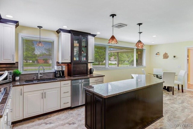 515 Park Club Ln, Amherst, NY 14221 - kitchen featuring dishwasher, a sink, decorative backsplash, dark stone counters, and glass insert cabinets