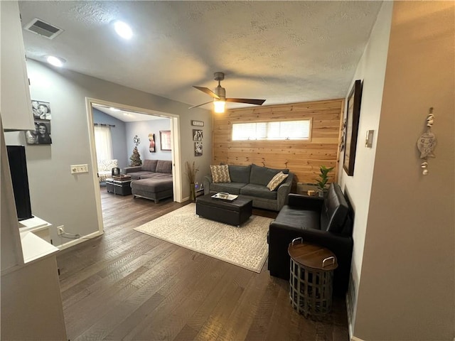 5545 E Lake Rd, Conesus, NY 14435 - living room featuring wood walls, a ceiling fan, an accent wall, dark wood-style floors, and baseboards