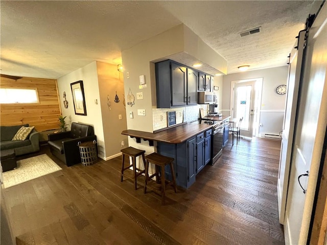 5545 E Lake Rd, Conesus, NY 14435 - kitchen featuring appliances with stainless steel finishes, dark wood-style floors, a textured ceiling, wooden walls, and baseboards
