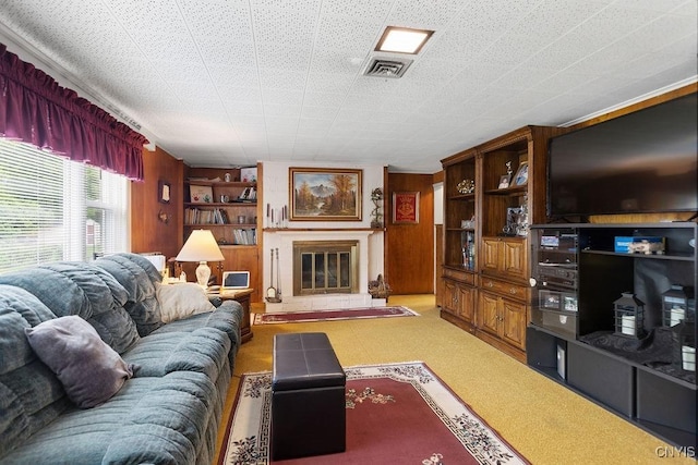 4922 Tenterden Dr, Onondaga, NY 13215 - living area featuring wood walls, light carpet, and a glass covered fireplace