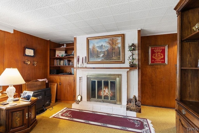 4922 Tenterden Dr, Onondaga, NY 13215 - living area with wood walls, a fireplace, and light carpet