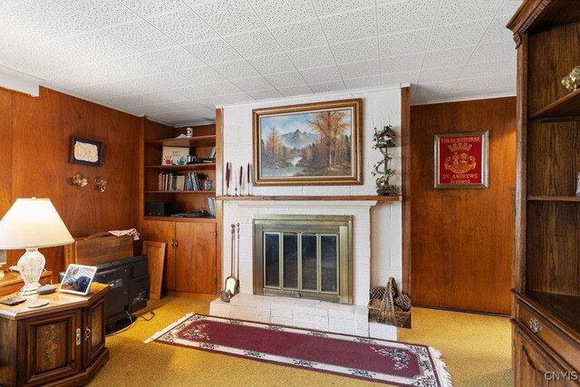 4922 Tenterden Dr, Onondaga, NY 13215 - living area with wooden walls, a fireplace, and light colored carpet