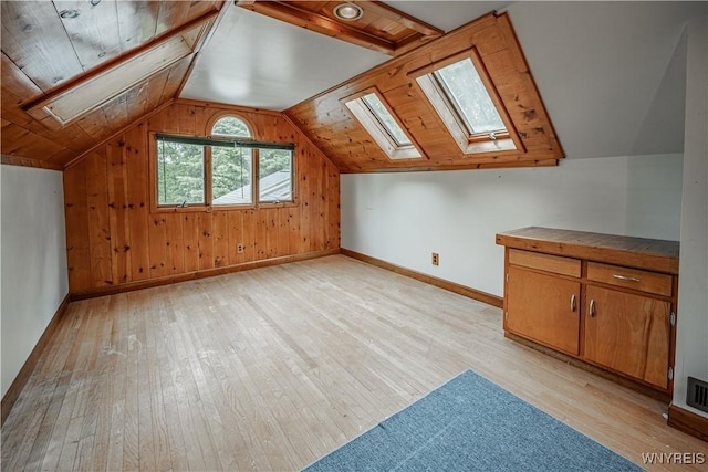 3557 Hartland Rd, Hartland, NY 14067 - bonus room featuring a skylight, light wood-style flooring, baseboards, vaulted ceiling, and wooden walls