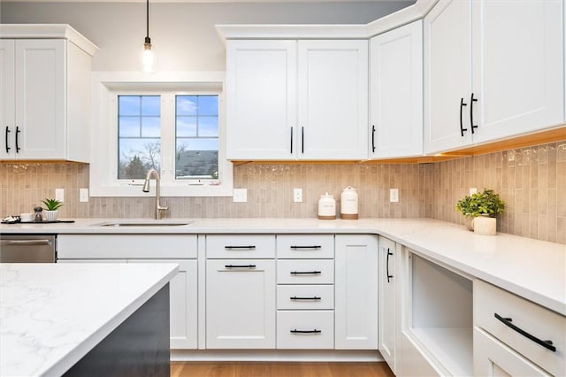 30 Legends Way, Greece, NY 14612 - kitchen featuring a sink, white cabinetry, decorative backsplash, and hanging light fixtures