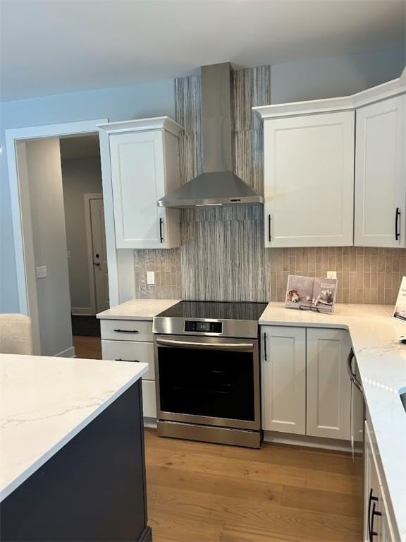 30 Legends Way, Greece, NY 14612 - kitchen with wall chimney exhaust hood, electric range, white cabinetry, and light wood finished floors