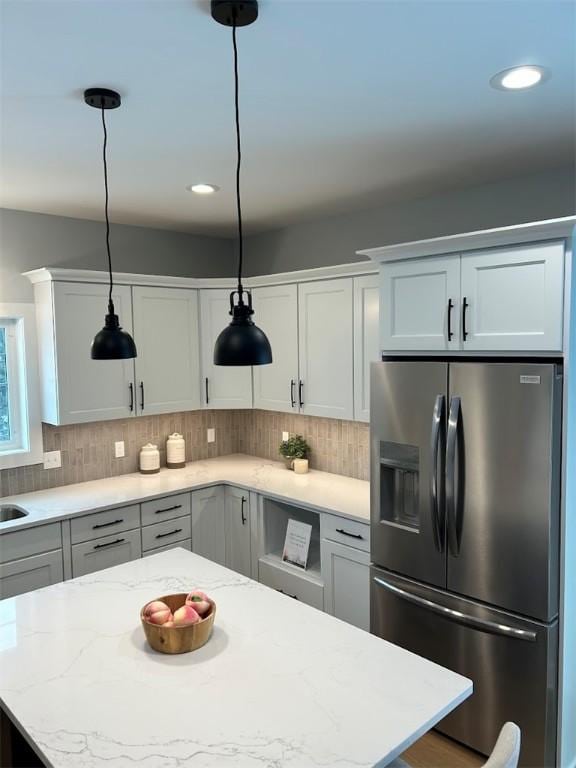 30 Legends Way, Greece, NY 14612 - kitchen with stainless steel fridge, backsplash, decorative light fixtures, a kitchen island, and light stone countertops