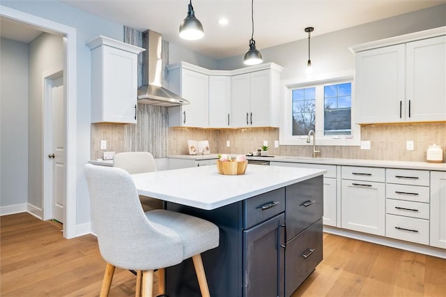 30 Legends Way, Greece, NY 14612 - kitchen featuring wall chimney exhaust hood, a sink, white cabinets, light countertops, and backsplash