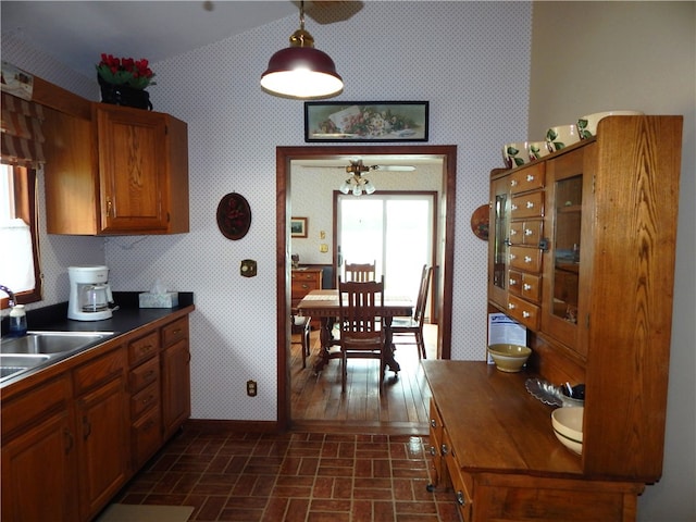 6731 Lake Salubria Dr, Bath, NY 14810 - kitchen featuring wallpapered walls, baseboards, brick patterned floors, a sink, and brown cabinets