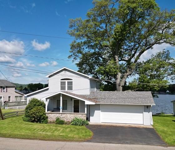6731 Lake Salubria Dr, Bath, NY 14810 - view of front facade with asphalt driveway, stone siding, and a garage