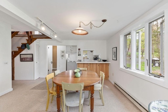 3435 E Lake Rd, Skaneateles, NY 13152 - dining area featuring light carpet, a baseboard heating unit, rail lighting, and washer / dryer