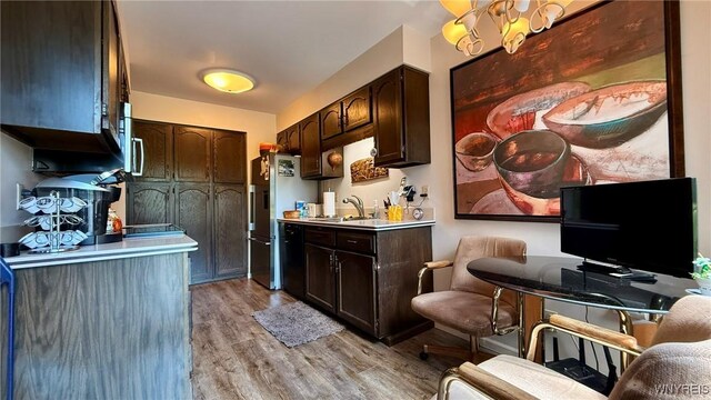 3134 E River Rd, Grand Island, NY 14072 - kitchen featuring freestanding refrigerator, a sink, dark brown cabinets, and light countertops