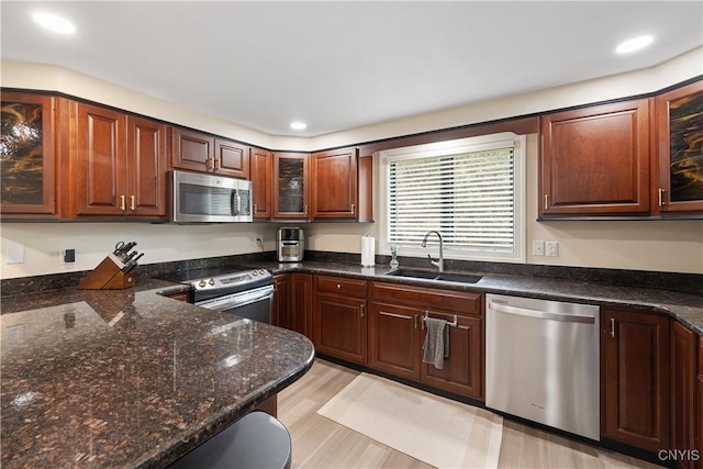 147 Crooked Lake Rd, Tully, NY 13159 - kitchen with stainless steel appliances, glass insert cabinets, dark stone countertops, light wood-type flooring, and recessed lighting