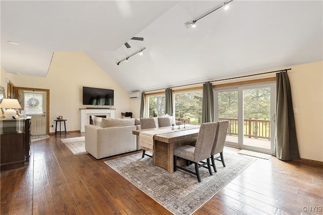 147 Crooked Lake Rd, Tully, NY 13159 - dining room with track lighting, vaulted ceiling, a wall mounted air conditioner, dark wood finished floors, and a fireplace