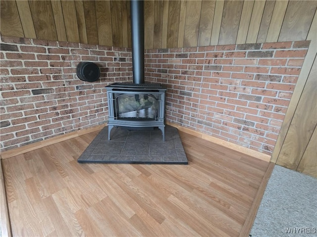 4003 Wood Rd, Albion, NY 14411 - detailed view of a wood stove, wood finished floors, brick wall, and baseboards