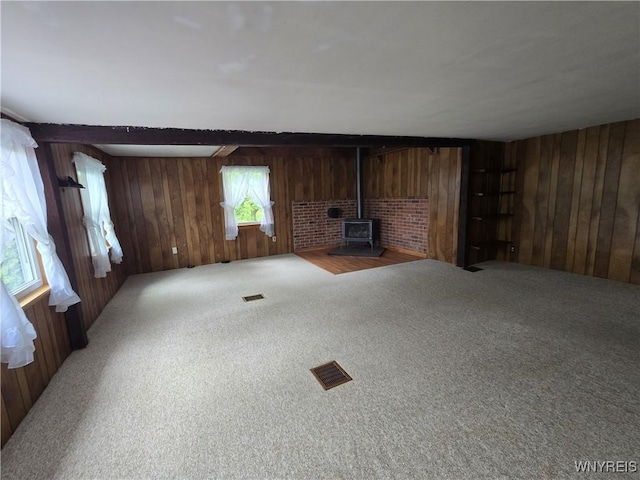4003 Wood Rd, Albion, NY 14411 - unfurnished living room with wood walls, a wood stove, and carpet floors