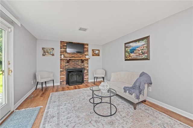 1 Briar Way, Perinton, NY 14450 - living area featuring wood finished floors, a brick fireplace, and baseboards
