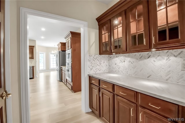 25 Davinci Ct, Amherst, NY 14221 - kitchen with appliances with stainless steel finishes, decorative backsplash, light countertops, glass insert cabinets, and recessed lighting