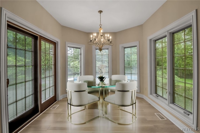25 Davinci Ct, Amherst, NY 14221 - dining area with a chandelier, wood finished floors, and baseboards
