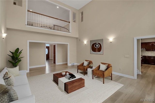 25 Davinci Ct, Amherst, NY 14221 - living room featuring a towering ceiling, light wood finished floors, and baseboards