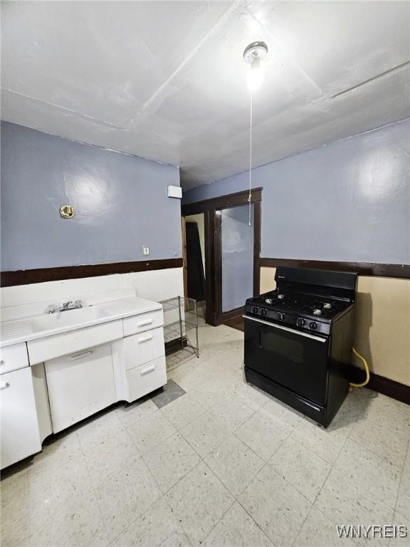 157 Victoria Ave, Buffalo, NY 14214 - kitchen featuring gas stove, light floors, baseboards, a sink, and light countertops