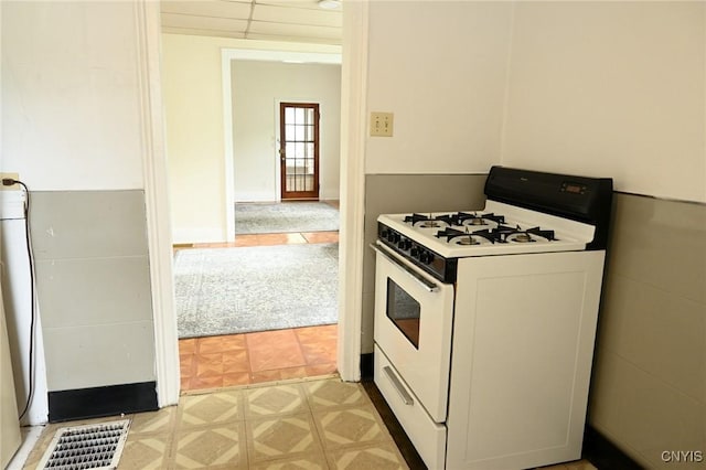 801 Ballantyne Rd, Syracuse, NY 13207 - kitchen featuring white range with gas cooktop, light flooring, and light countertops