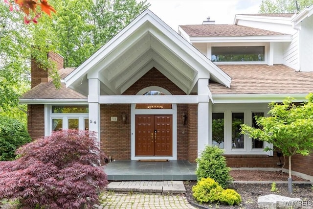 54 Contessa Ct, Amherst, NY 14221 - property entrance with brick siding, a chimney, and roof with shingles