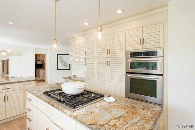 54 Contessa Ct, Amherst, NY 14221 - kitchen featuring appliances with stainless steel finishes, light stone counters, recessed lighting, decorative light fixtures, and light wood-type flooring