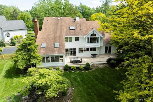 54 Contessa Ct, Amherst, NY 14221 - back of property featuring a chimney, a shingled roof, a wooden deck, and a yard
