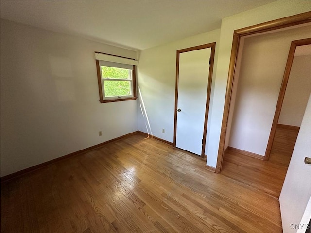 9385 Wickham Dr, Cicero, NY 13029 - unfurnished bedroom with wood finished floors and baseboards